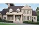 A classic brick two-story home featuring a covered entrance, symmetrical windows, and lush landscaping at 4812 Parker Meadow Dr, Raleigh, NC 27614