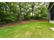 Lush backyard with a well-maintained lawn and mature trees at 5208 Knollwood Rd, Raleigh, NC 27609