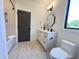 Well-lit bathroom features modern fixtures, including a large vanity, mirror, and tub with shower at 5208 Knollwood Rd, Raleigh, NC 27609