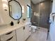 Modern bathroom showcasing a geometric mirror, marble countertops, and a glass-enclosed shower at 5208 Knollwood Rd, Raleigh, NC 27609