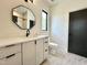Well lit bathroom with modern vanity, sleek fixtures, and geometric mirror at 5208 Knollwood Rd, Raleigh, NC 27609