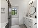 Bathroom with a bathtub, shower, and white vanity with geometric mirror and stone countertop at 5208 Knollwood Rd, Raleigh, NC 27609