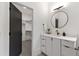 Modern bathroom featuring a walk-in closet, round mirror, and white vanity with beautiful stone countertop at 5208 Knollwood Rd, Raleigh, NC 27609