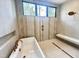 Soaking tub with modern fixtures, complemented by stylish tile and a large window for natural light at 5208 Knollwood Rd, Raleigh, NC 27609