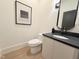 Contemporary half-bathroom featuring black and white decor, a modern mirror, and a stylish vanity at 5208 Knollwood Rd, Raleigh, NC 27609