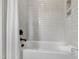 Clean bathtub with tile surround, a white curtain, and a towel with toiletries at 5208 Knollwood Rd, Raleigh, NC 27609