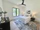 Bright bedroom featuring a modern ceiling fan, a patterned rug, and a view from a large window at 5208 Knollwood Rd, Raleigh, NC 27609