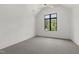 Minimalist bedroom with a large window providing natural light and a ceiling fan at 5208 Knollwood Rd, Raleigh, NC 27609
