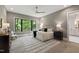 Serene bedroom with modern furnishings, large windows showcasing lush greenery, and hardwood flooring at 5208 Knollwood Rd, Raleigh, NC 27609