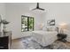 Cozy bedroom features neutral decor, a ceiling fan and a large window with a neighborhood view at 5208 Knollwood Rd, Raleigh, NC 27609