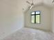 Bright bedroom with a vaulted ceiling, modern fan, and a large window providing outdoor views at 5208 Knollwood Rd, Raleigh, NC 27609