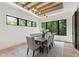 Bright dining room featuring a modern chandelier, wood beam ceiling accent, and views of the surrounding greenery at 5208 Knollwood Rd, Raleigh, NC 27609