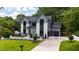 Exterior shot showcasing a modern home with a well-manicured lawn, and long driveway at 5208 Knollwood Rd, Raleigh, NC 27609