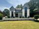 Striking two-story home featuring a manicured lawn, modern design, and professionally landscaped yard at 5208 Knollwood Rd, Raleigh, NC 27609