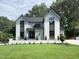Beautiful two-story home featuring a well-manicured lawn and a white brick retaining wall at 5208 Knollwood Rd, Raleigh, NC 27609