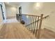 Hallway with wooden floors, black railings, white trim, and modern lighting fixtures at 5208 Knollwood Rd, Raleigh, NC 27609