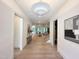 Bright and airy hallway with hardwood floors, elegant lighting, and modern artwork leading to the living spaces at 5208 Knollwood Rd, Raleigh, NC 27609