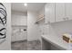 Bright laundry room with ample white cabinets, countertop, and modern tile flooring at 5208 Knollwood Rd, Raleigh, NC 27609