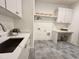 Well-organized laundry room with ample counter space, storage cabinets, and modern appliances on tiled floor at 5208 Knollwood Rd, Raleigh, NC 27609