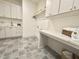 Bright and spacious laundry room featuring modern cabinets, countertops, sink, and stylish tile flooring at 5208 Knollwood Rd, Raleigh, NC 27609
