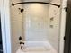 Cozy tiled shower with a tub, black fixtures, and built-in niche at 5208 Knollwood Rd, Raleigh, NC 27609