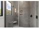 Sleek bathroom shower with gray tiled walls, a built-in seat, and a window for natural light at 5208 Knollwood Rd, Raleigh, NC 27609