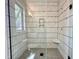 Modern tiled shower with glass enclosure, built-in shelf, and sleek fixtures at 5208 Knollwood Rd, Raleigh, NC 27609