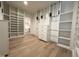 Spacious walk-in closet with custom shelving, drawers, and ample storage space on light hardwood floors at 5208 Knollwood Rd, Raleigh, NC 27609
