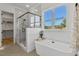 Bathroom boasts a freestanding tub, glass shower, and large window providing natural light and scenic views at 55 Harvest View Way, Franklinton, NC 27525