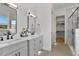 Bathroom featuring dual sinks, modern black fixtures, and a glass-enclosed shower and walk-in closet at 55 Harvest View Way, Franklinton, NC 27525