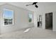 Bedroom with gray carpet, two windows, ceiling fan, and entry to bathroom at 55 Harvest View Way, Franklinton, NC 27525