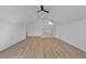 A bonus room featuring wood floor, a ceiling fan and a doorway with steps leading to another room at 55 Harvest View Way, Franklinton, NC 27525