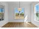 Bright dining room with hardwood floors, large window, and modern light fixture at 55 Harvest View Way, Franklinton, NC 27525
