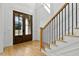 Elegant foyer with hardwood floors, a staircase, and a glass-paneled front door allowing natural light at 55 Harvest View Way, Franklinton, NC 27525