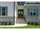 Elegant front entry with stone steps, double doors, and manicured landscaping at 55 Harvest View Way, Franklinton, NC 27525