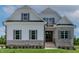 Inviting two-story home featuring stone accents, vertical siding, and a beautifully landscaped front yard at 55 Harvest View Way, Franklinton, NC 27525