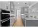 Bright kitchen features gray cabinets, stainless appliances, granite counters, and hardwood floors at 55 Harvest View Way, Franklinton, NC 27525