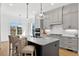 Island kitchen features an eat in bar, stainless appliances, updated cabinetry, and sleek hardware at 55 Harvest View Way, Franklinton, NC 27525