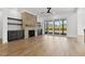 Spacious living room boasts a stone fireplace, built-in shelving, hardwood floors, and sliding glass doors to a balcony at 55 Harvest View Way, Franklinton, NC 27525