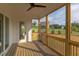 This screened porch features a ceiling fan and is adjacent to the backyard with lush greenery at 55 Harvest View Way, Franklinton, NC 27525