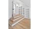 Close up of a staircase featuring hardwood steps with built-in shelving and access to a hallway at 55 Harvest View Way, Franklinton, NC 27525