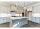 Modern kitchen with white cabinets, quartz countertops, and a large island at 6052 Scalybark, Durham, NC 27712