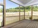 Charming screened porch featuring a wood railing with wooded views at 6052 Scalybark Rd, Durham, NC 27712