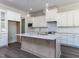 Modern kitchen featuring a large island with quartz countertops and a sink at 6052 Scalybark Rd, Durham, NC 27712