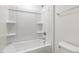 Clean and bright bathroom with a tub-shower combo, shelving, and tiled wall at 117 Shelby Meadow Ln, Angier, NC 27501