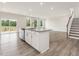 Open floor plan with kitchen island, stainless steel appliances, and wood floors at 117 Shelby Meadow Ln, Angier, NC 27501