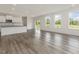 Open-concept living space with large windows, hardwood floors, and a kitchen area with white cabinetry at 117 Shelby Meadow Ln, Angier, NC 27501