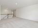 Expansive carpeted living area with neutral walls and a view of the staircase at 117 Shelby Meadow Ln, Angier, NC 27501