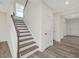 Well-lit staircase with wooden steps and white risers, leading to the upper level at 117 Shelby Meadow Ln, Angier, NC 27501