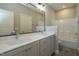 Double vanity bathroom with grey cabinets, quartz countertops, and a shower/tub at 6048 Scalybark Rd, Durham, NC 27712